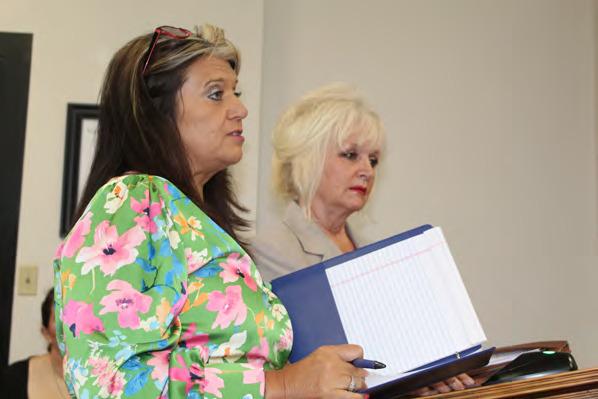 Van Zandt County Human Resource Coordinator Jessica Deville (foreground) and D’Ann Miller with Hibbs Hallmark of Tyler discussed the renewal of the county paid standard life insurance policy for VZC employees and retirees May 8 during the regular meeting of the VZC Commissioners Court. Photo by David Barber