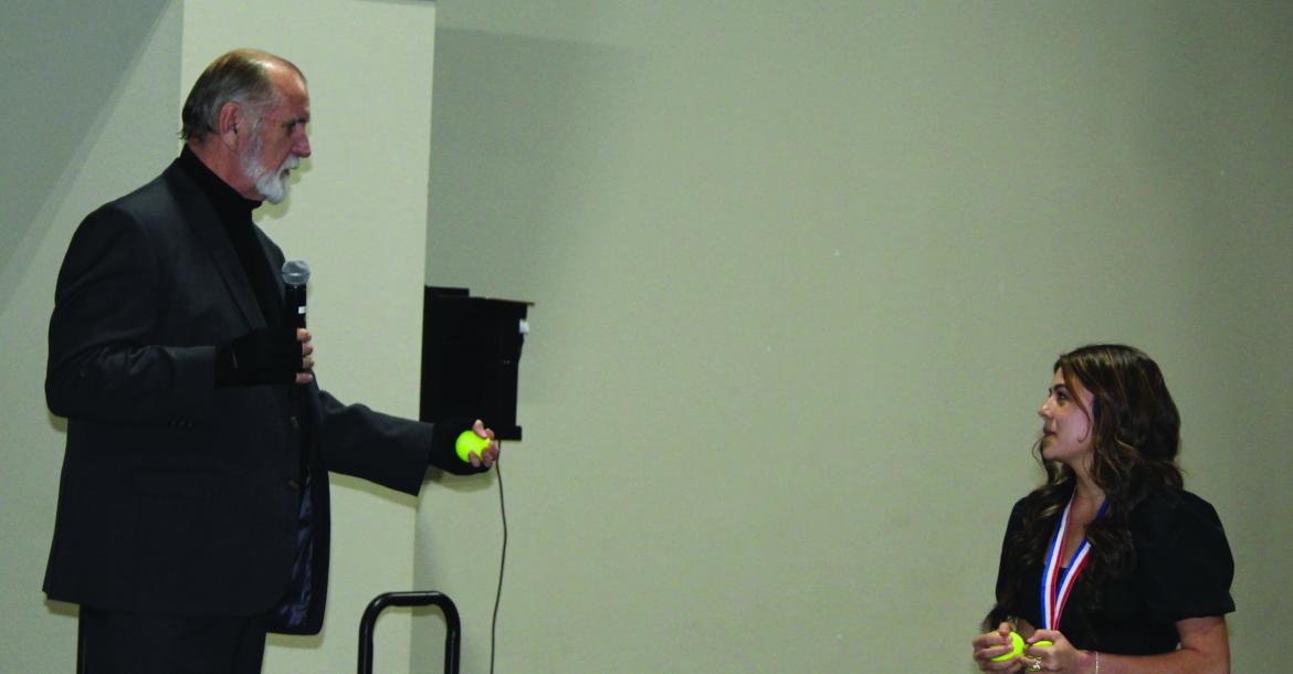 Martins Mill Lady Mustang freshman Kara Nixon was ‘challenged’ by guest speaker Larry Tidwell to juggle three tennis balls. Tidwell shared that he used the tennis ball juggling demonstration as a hand/eye coordination exercise when he was coaching. Photo by David Barber