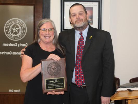 Retiring Van Zandt County Court Reporter Becky Wheeler was presented with an appreciation plaque for her 40 years of service by VZC County Court at Law Judge Josh Wintters March 26 during the regular meeting of the VZC Commissioners Court. Photo by David Barber