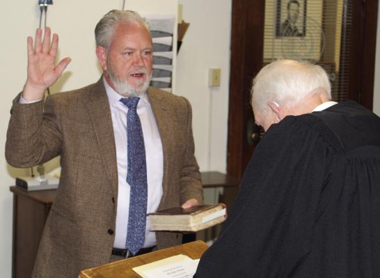 Newly appointed Van Zandt County Pct. 2 Commissioner Cliff Williams takes the oath of office Aug. 23. The oath of office was administered by Judge Bill Bass of Tyler, a personal friend of Williams. Photo by David Barber
