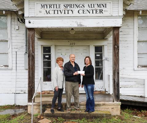 Joy Long, representing TVEC Charitable Foundation, presents $2,000 grant check to Myrtle Springs Alumni Association Board Member Bill Rusk and wife, Ida. Courtesy photo