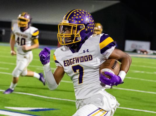 Edgewood’s Alex Coburn picks up a head of steam as he races along the home sidelines during bi-district round play against DeKalb. Photo by Dusty Goodwin