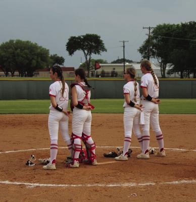 Mahayla McKinney (11), Maylan Hale (14), Jailey Potter (1) and Tatum Horton (2) stand at attention for the playing of the national anthem. Photo by Liz Hinch