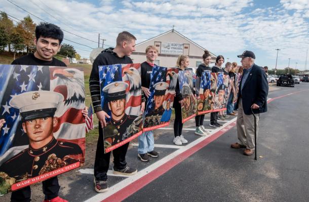 The Van Zandt County Veterans Memorial held a Veterans Day program on Nov. 11 in Canton. Veteran and VZC Veterans Memorial Board Member Cary Hilliard looks at the portraits of the fallen held by Martins Mill ISD students. Photo by Faith Caughron
