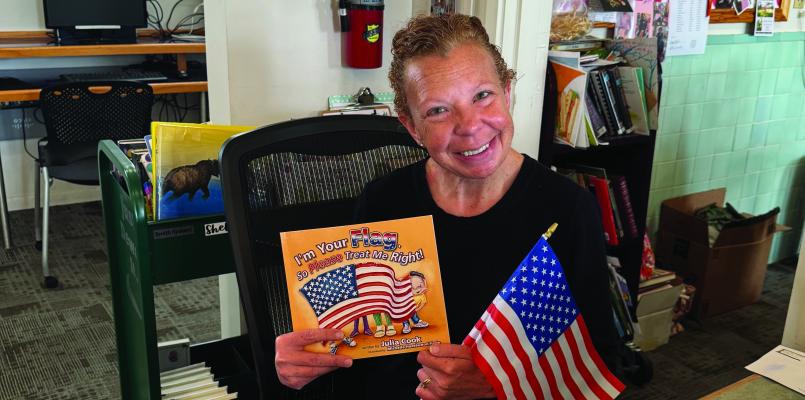 Grand Saline Public Library Librarian Brandi Collard is shown with one of the U.S. Flag children’s books donated by DAR. Courtesy photo