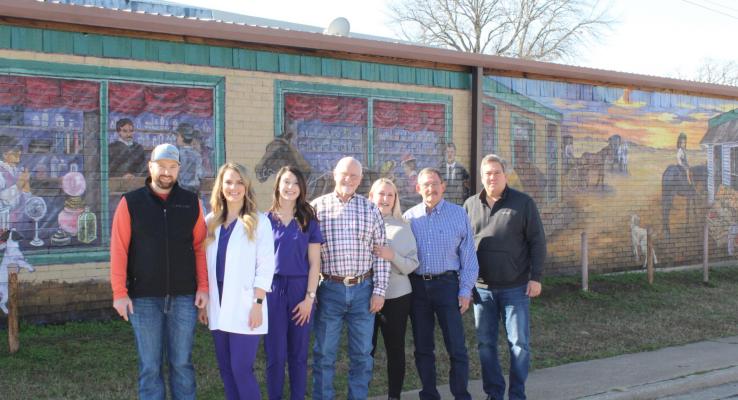 From left, pharmacy owners Jake and Holly Randolph, pharmacy tech Alex Arthur, Edgewood Mayor Steadham and his wife, Judy, Edgewood EDC member Charles Prater and Edgewood Heritage Museum President Stephen Goode stand before the mural. Courtesy photos