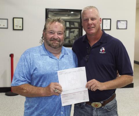 During the regular monthly meeting of the Van City Council July 10, Gene Keenon of Republic Services (left) presented a $1,000.00 donation check to the Van Fire Department. Accepting the check for the fire department was new Van Fire Department Chief Jeremie Thompson. Photo by David Barber