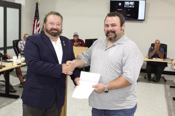 Gene Keenon of Republic Services (left) presented the company’s annual $1,000 donation check to Van Fire Chief Michael Duncan and the Van Volunteer Fire Department May 11 during the regular monthly meeting of the Van City Council. Photo by David Barber