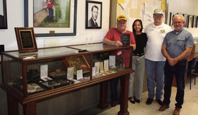 Dallas Fox of the Fox & Co.  Military Museum in Scurry (far  left) recently donated a display  of military memorabilia to the  Van Zandt County Courthouse.  The display is located next to  the front entrance of the VZC  Clerk’s office on the second  f loor of the courthouse. Fox  also presented a plaque to VZC  which was accepted by VZC  Veterans Service Officer Tom my Forgue (second from right).  The plaque read, ‘Dedicated to  preserving the legacy of those  who served.’ Also shown were  Fox’s granddaught