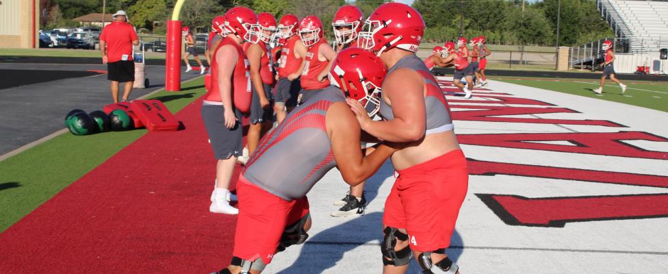 An offensive lineman and a defensive lineman work against one another to improve their skills during the first day of pre-season practices Aug. 1. Photo by David Barber