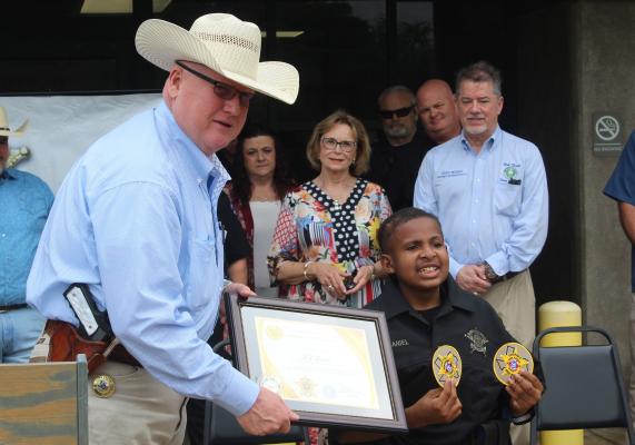 Van Zandt County Pct. 4 Constable Bob Keltner presented DJ Daniel with a plaque April 4 during a special ceremony as Daniel was named as an Honorary VZC Sheriff’s Department Deputy. Photo by David Barber
