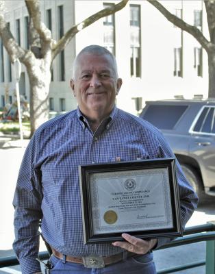 Van Zandt County Sheriff Joe Carter holds the ‘Certificate of Compliance’ recently awarded to the VZC Jail by the Texas Commission on Jail Standards. VZC Judge Don Kirkpatrick announced the accomplishment during the regular meeting of the VZC Commissioners Court Oct. 26. Photo by Ethan Adams
