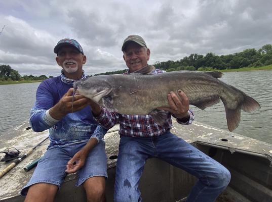 Guide J.C. McCullough (left) and Luke with a big blue catfish last week from the Red River below Lake Texoma. Photo by Jeff Rice