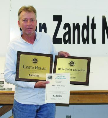 Van Zandt Newspapers L.L.C. Graphic Designer Tim Ball holds three awards won in the Texas Better Newspaper Contest sponsored by the Texas Press Association (TPA). Photo by David Barber