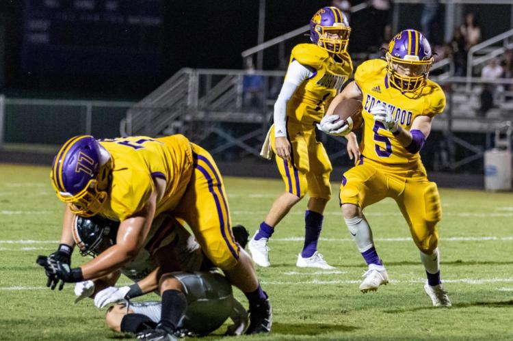 Top, Noah Boone (5) follows a pancake block by junior Layton Bass (77) during Edgewood’s season-opening win over the visiting Commerce Tigers. Photo by Dusty Goodwin