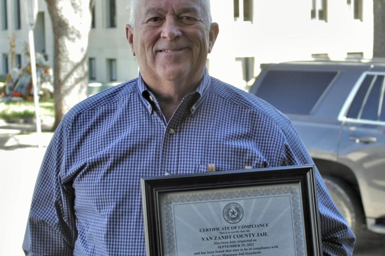 Van Zandt County Sheriff Joe Carter holds the ‘Certificate of Compliance’ recently awarded to the VZC Jail by the Texas Commission on Jail Standards. VZC Judge Don Kirkpatrick announced the accomplishment during the regular meeting of the VZC Commissioners Court Oct. 26. Photo by Ethan Adams